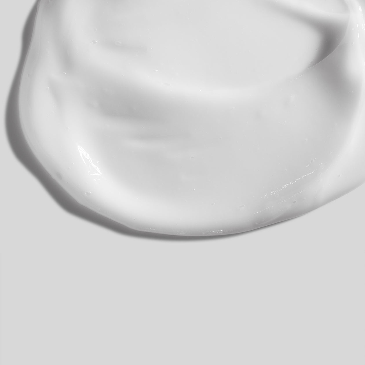 A creamy dollop of Obagi Hydrate® Lightweight Moisturizer spread on a clean, smooth white surface, showcasing its rich yet lightweight texture designed for 24-hour hydration.